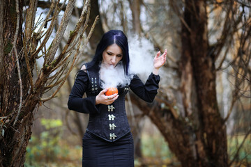 A woman in a witch suit in a forest