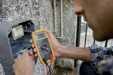 Electrician using a voltmeter device