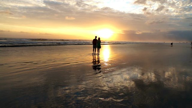Silhouette of couple admire sunset on beach, super slow motion 240fps
