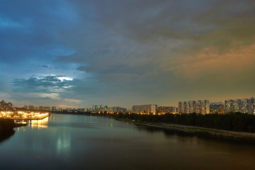 Fototapeta na wymiar Cityscape at dusk with thunderstorm over apartments buildings