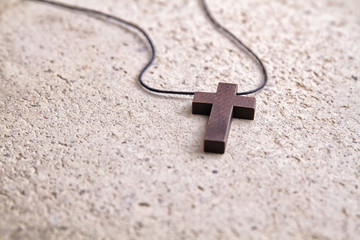 Wooden cross necklace on a stone