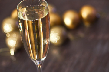 a glass of champagne on the background of Christmas balls