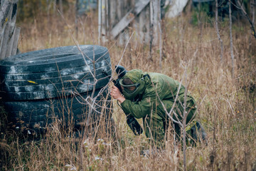 Man with gun playing at paintball. Outdoors