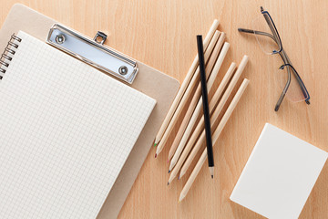 business objects of pencils,white paper note,and glasses on wooden office desk for business background and design.