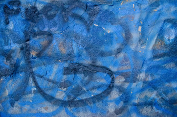 Blue, white, gray and black paint sprayed on a large rocky surface