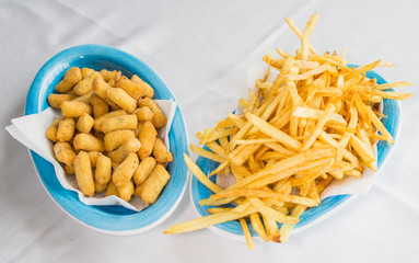 2 piattini con patatine fritte e panzerotti di patate