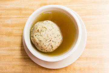 bowl of matzo ball soup with giant matzo ball