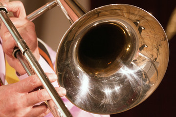 Obraz premium The musician plays a jazz melody on a trombone. Close-up. For music news.