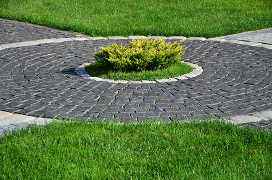 A Beautiful New Walkway Made Of Paving Stone Is Located Among The Green Grass