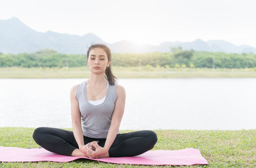 Fototapeta na wymiar Attractive young woman exercising and sitting in yoga