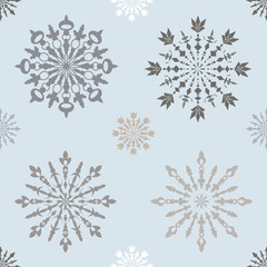 Fototapeta premium Seamless pattern with large and small blue patterned snowflakes on white background
