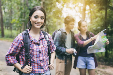Asian Group of young people Hiking with friends backpacks walking together and looking map and taking photo camera by the road and looking happy ,Relax time on holiday concept travel