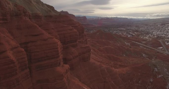 Aerial drop alongside a massive red ridge in Utah National Park
