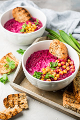 Beetroot cream soup with coconut milk, baked chickpeas, sesame, parsley on a gray concrete background. Baked chickpeas with spices. Useful dietary snack and lunch. Place for text. Flat lay, top view