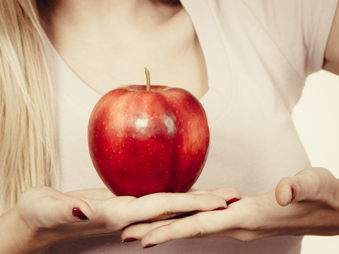 Woman hand holding delicious red apple