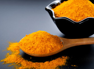 Turmeric powder on black background.