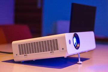 projector for presentation in a meeting room with notebook background, (Light in a light yellow...