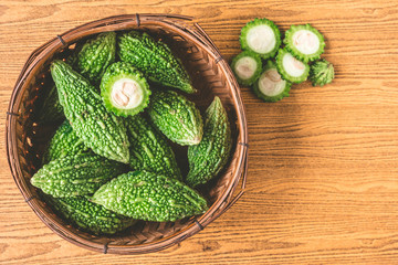 Bitter melon or bitter gourd in wooden basket. Free space for taxt