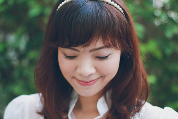 Fototapeta premium Close up of young pretty Asian woman in the garden.