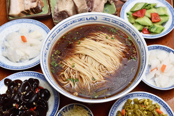 Chinese style soup noodles with side dishes on the wooden table           