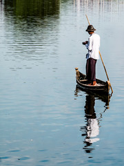The duck keeper on the wooden boat looking after the ducks in Taungthaman Lake at U Bein Bridge,...