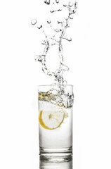 Lemon splashes in  water glass isolated on white background