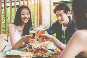 Two asian woman and one men.Drinking beer,are smile.Group celebration party eating happy, concept
