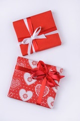 Two holiday red boxes on white wooden background