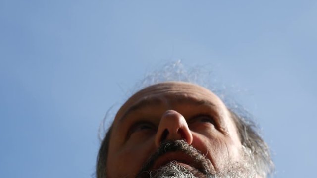 Visione mistica nel cielo sguardo di uomo con barba grigia