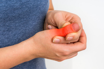 Woman with finger pain is holding her aching finger