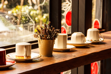 Cups on the shelf in warm sunlight in Romantic Atmosphere of Coffee Shop
