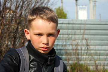 Serious,slightly smiling teen boy with a backpack.