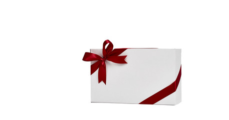 The white box wrapped with red ribbon with a bow