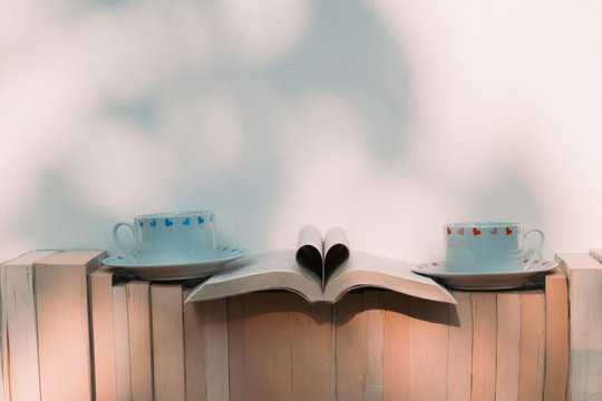 Open book  in heart shape with two cups of coffee and books on the shelf - Retro vintage filter effect