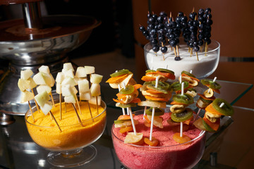Sweet fruit and berry canapes on a glass table in a restaurant
