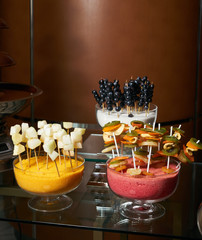 Sweet fruit and berry canapes on a glass table in a restaurant
