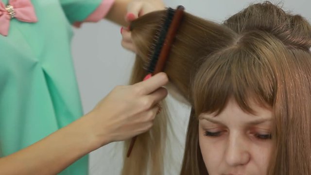 A professional stylist makes a hairstyle for the model. Fashion world.
