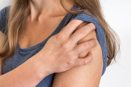 Woman with shoulder pain is holding her aching arm