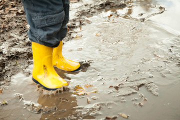 child in yellow rubber boots