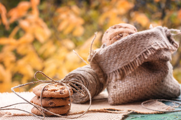 Homemade oatmeal cookies in burlap and folded in a pile on the old table. Cookies tied with a rope. Toned photo. Nature and food concept. A place for your inscription.