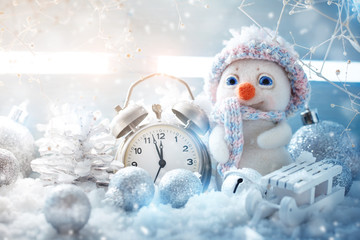 Christmas winter a background, the small snowman stands with a clock. Happy New Year. Merry Christmas.