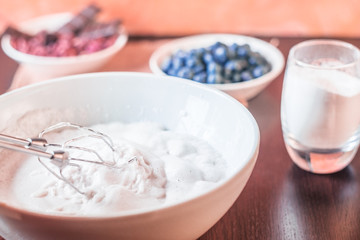 Whipped egg whites for meringue. Mixing white egg cream in bowl with motor mixer, baking cake. Anna Pavlova meringue. Whipped egg whites and sugar powder. Baking dessert concept