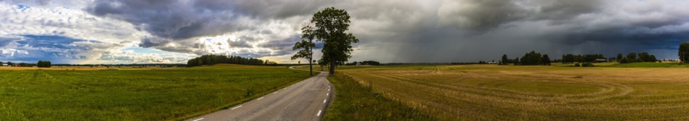 Super panorama of the Swedish flatlands with clear sky’s on one side and dark clouds lurking on the other.         