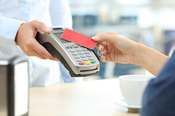 Girl paying with a contactless credit card reader in a bar