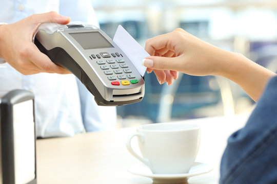Waiter charging with credit card reader in a bar