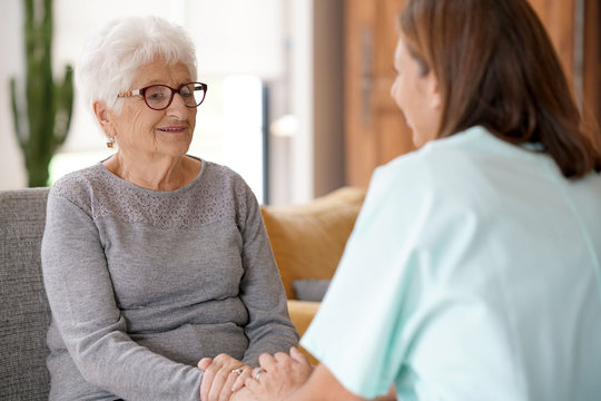 Nurse talking to old woman, assistance and support