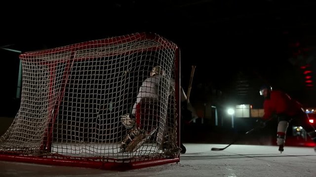Professional hockey players play the shootout. The player who takes the penalty a hockey goalkeeper. Steadicam.