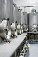 A lot of stainless steel tanks with large round hatches, modern beverage production.