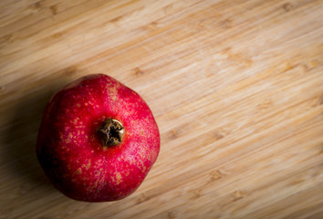 Fresh red pomegranate on the wood background, studio shot
