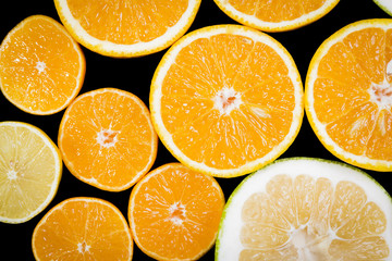 Citrus fruits (orange, lemon, grapefruit, mandarin, lime) isolated on the black background. Fruit food background. Fresh citrus fruit assortment